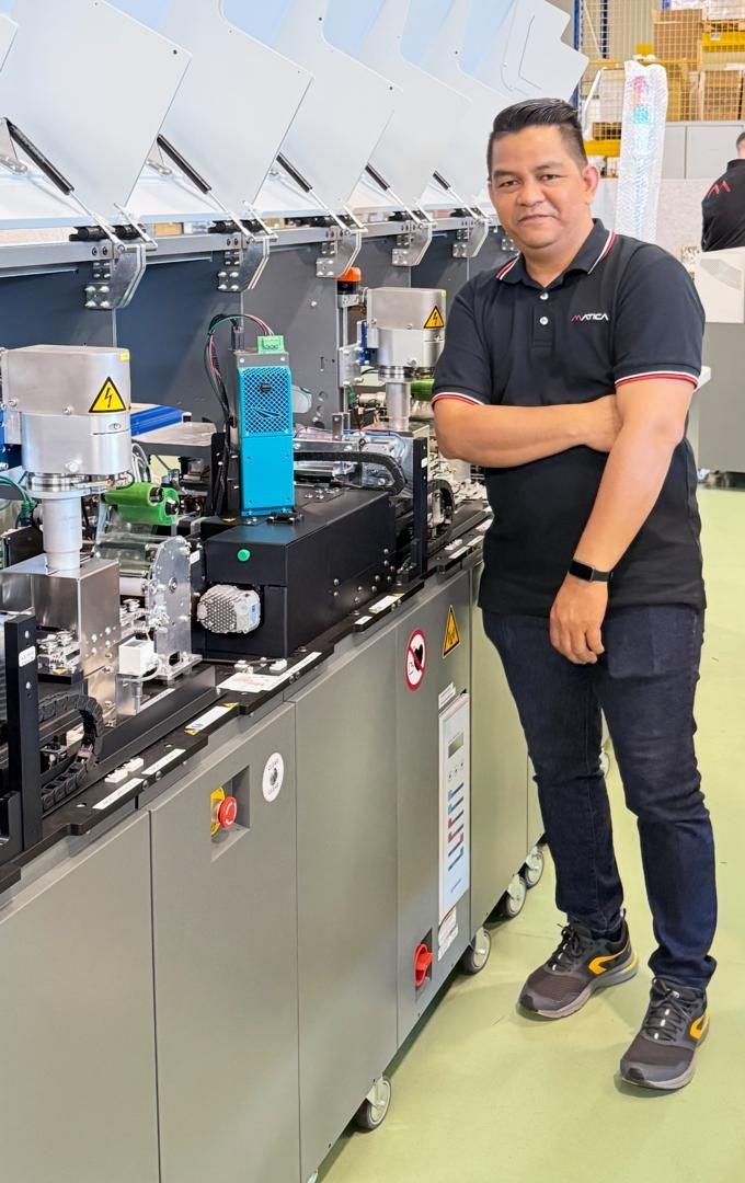 Ronnel Besagre beside a Matica S8000 central issuance line